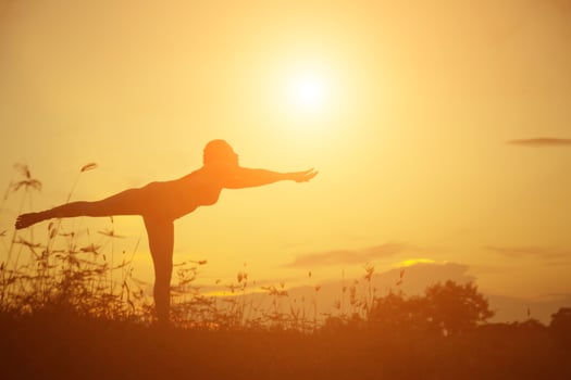 Silhouette of woman praying over beautiful sky background photo