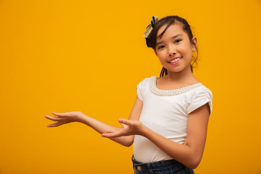 Asian child presenting product, brand or text that can be inserted beside. Copy space. photo