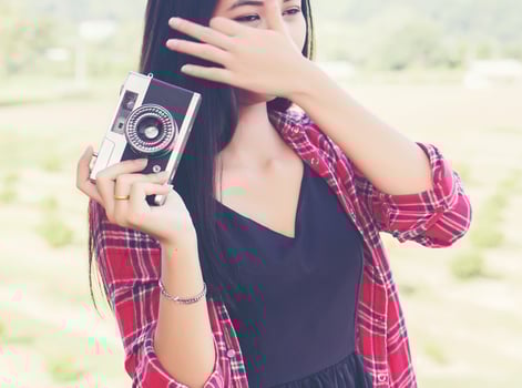 Young hipster woman photographer holding a vintage camera. photo