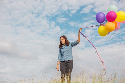 Beautiful Girl jumping with balloons on the beach photo