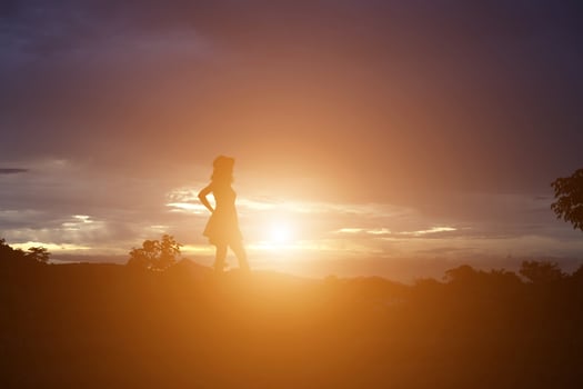 Silhouette of woman praying over beautiful sky background photo