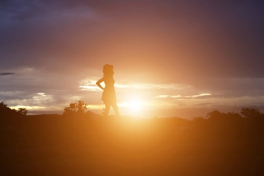 Silhouette of woman praying over beautiful sky background photo