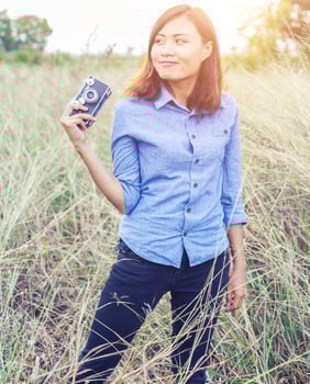Vintage of beautiful women photography standing hand holding retro camera with sunrise,dream soft style photo