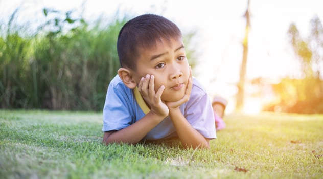 Happy boy child is smiling enjoying adopted life. Portrait of young boy in nature, park or outdoors. Concept of happy family or successful adoption or parenting. photo