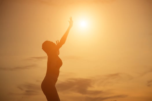 Silhouette of woman praying over beautiful sky background photo