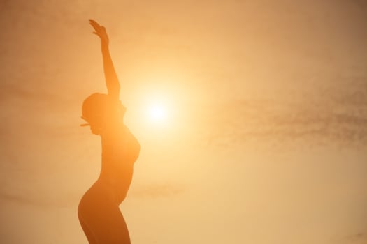 Silhouette of woman praying over beautiful sky background photo