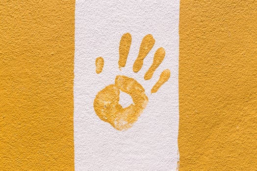 Hand print on orange and white wall photo