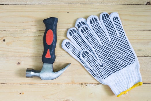 Gloves and hammer on wooden floor photo