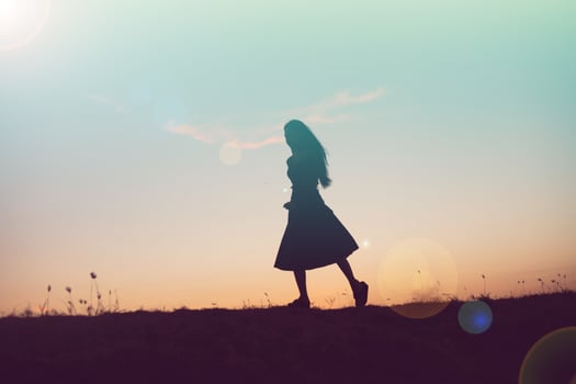 silhouette of a young woman standing alone photo