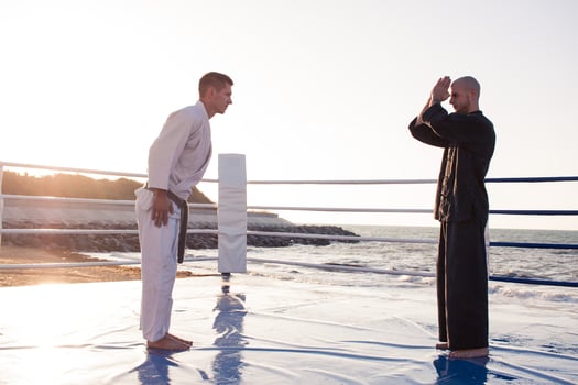karate fighters are fighting on the beach boxing ring in morning photo
