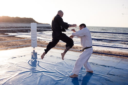 karate fighters are fighting on the beach boxing ring in morning photo