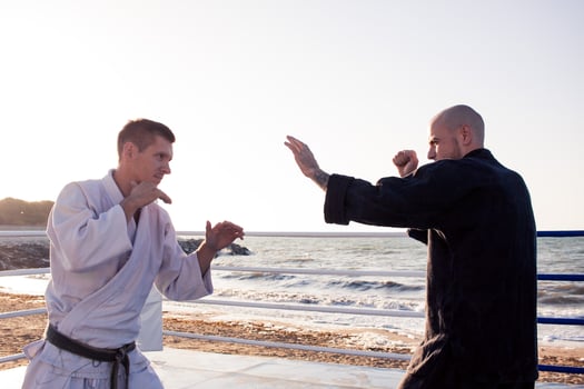 karate fighters are fighting on the beach boxing ring in morning photo