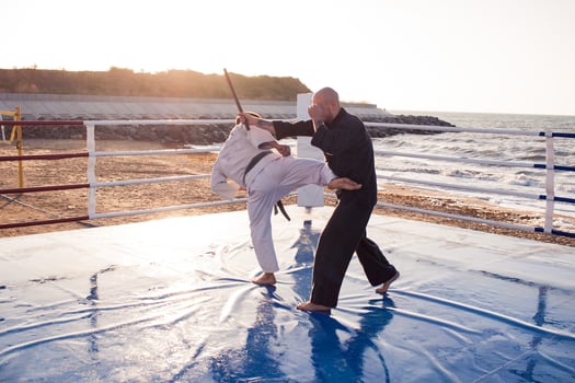 karate fighters are fighting on the beach boxing ring in morning photo