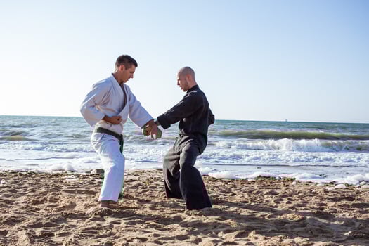 karate fighters are fighting on the beach boxing ring in morning photo