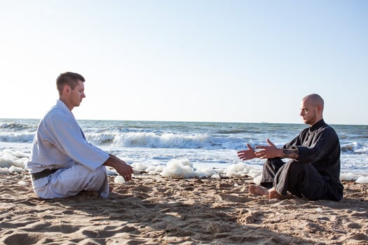 karate fighters are fighting on the beach boxing ring in morning photo