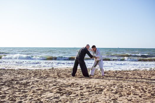 karate fighters are fighting on the beach boxing ring in morning photo