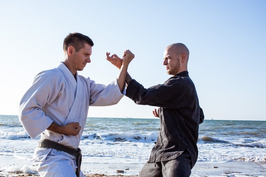 karate fighters are fighting on the beach boxing ring in morning photo