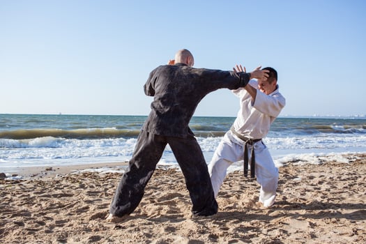 karate fighters are fighting on the beach boxing ring in morning photo