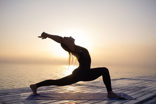 young woman posing in yoga asans, morning sea background photo