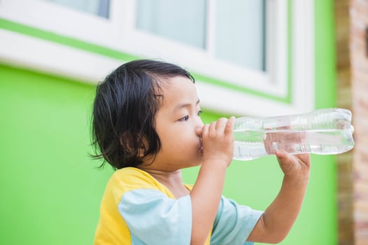Thirsty Girl Drinking Water Outdoors photo