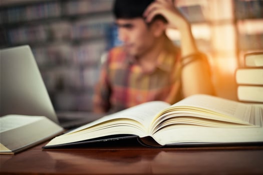 Young male student studying in the library photo