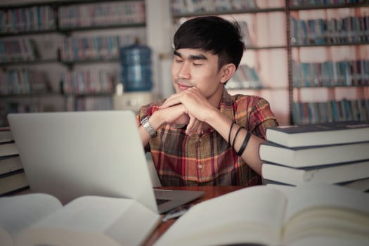 Young male student studying in the library photo