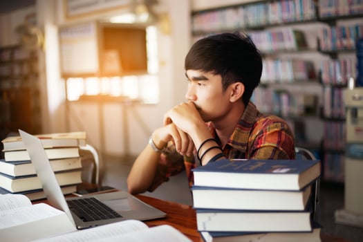 Young male student studying in the library photo
