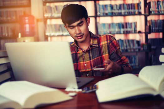 Young male student studying in the library photo