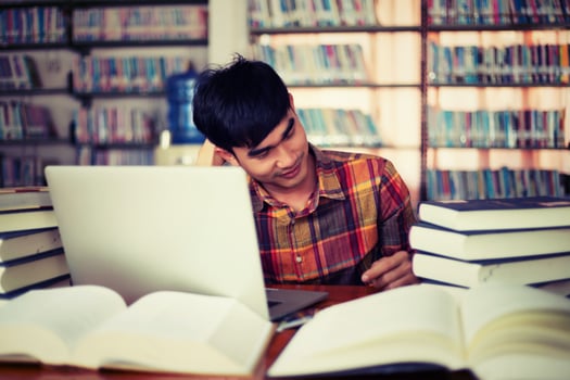 Young male student studying in the library photo