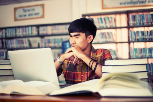 Young male student studying in the library photo