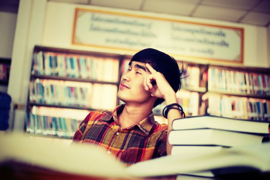Young male student studying in the library photo