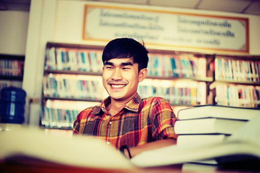 Young male student studying in the library photo