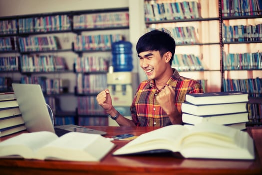 Young male student studying in the library photo