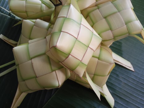 Ketupat, a type of dumpling made from rice packed inside a diamond-shaped container of woven palm leaf pouch. commonly found in Indonesia, Malaysia, Brunei, Singapore, and the Philippines. photo
