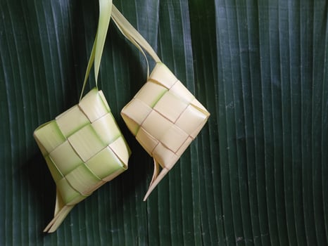 Ketupat, Indonesian rice cooking on green  background. Ketupat is a natural rice casing made from young coconut leaves for cooking rice during eid Mubarak, Eid ul Fitr photo