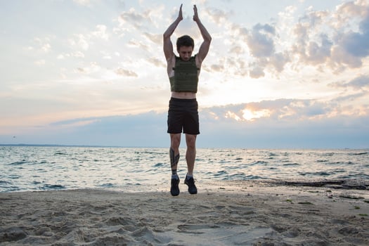 Young bearded athlete training outdoor with weighted vest, exercise with military plate carrier photo