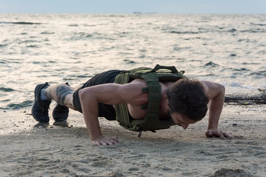 Young bearded athlete training outdoor with weighted vest, exercise with military plate carrier photo