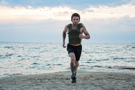 Young bearded athlete training outdoor with weighted vest, exercise with military plate carrier photo