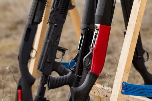 Male training with pump action shotgun outdoors in field. photo