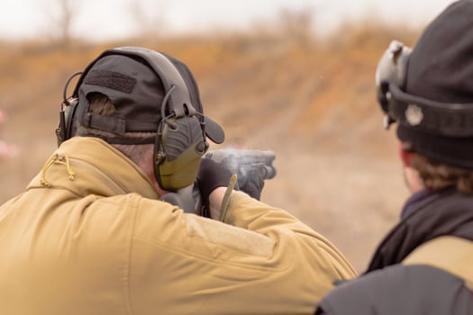 Male training with pump action shotgun outdoors in field. photo