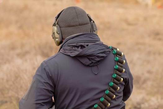 Male training with pump action shotgun outdoors in field. photo