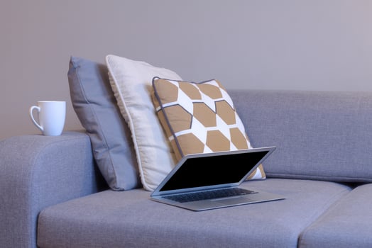 laptop in bedroom with bed, lamp and home decor background. photo