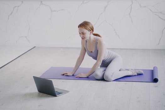 Young woman practicing yoga internet fitness lesson on self isolation. Home online classes. photo