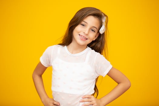Portrait of a happy smiling child girl in yellow background. photo