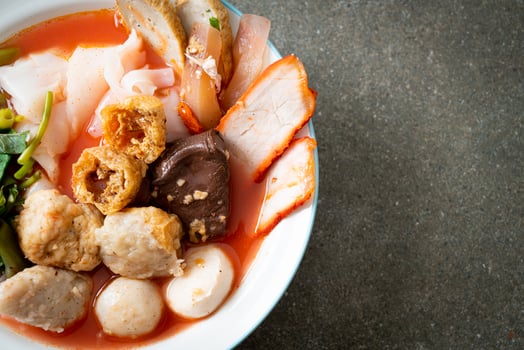 noodles with meatballs in pink soup photo
