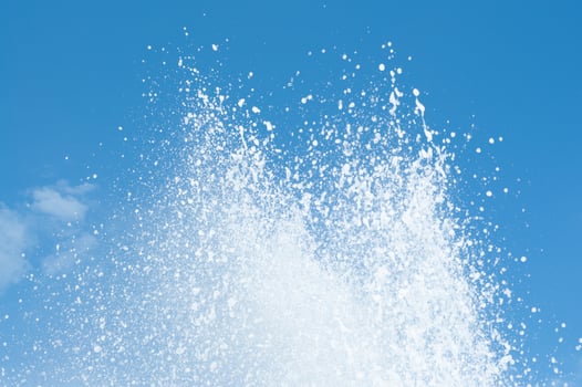 Cool and fresh water splashes on the clear blue sky background. photo