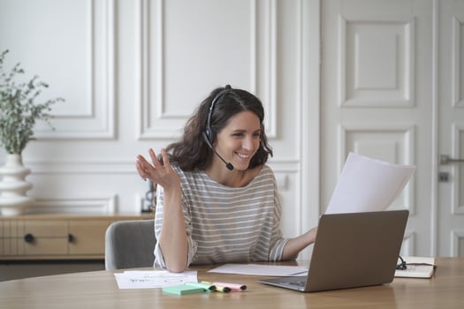 Young excited cheerful female coach in headset with microphone conducts private consultations online photo