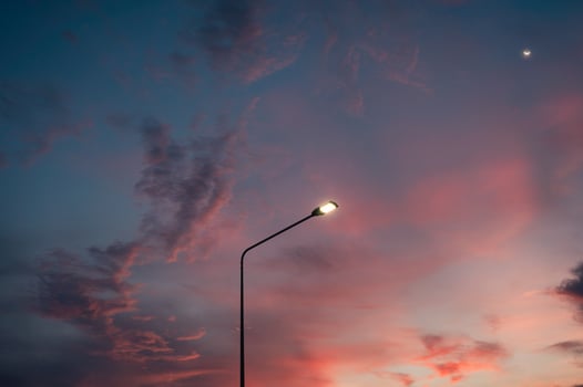 Street light pole with the moon and evening sky photo