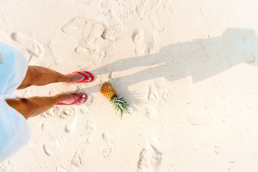 Summer beach vacation with pineapples and flip flops on the beach photo