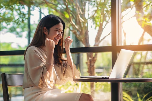 Happiness success Asian businesswoman happy while using laptop computer for business result photo